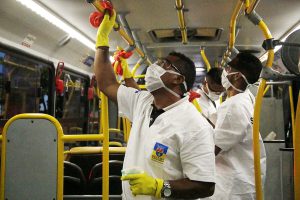 People sanitizing the inside of a public bus