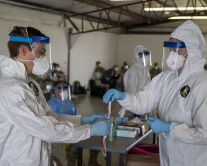 A Nebraska Air National Guard collecting nasopharyngeal samples with Nebraska Air National Guard Staff from first responders and healthcare workers at a mobile testing site