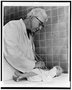 Dr. Virginia Apgar taking the heartbeat of a newborn