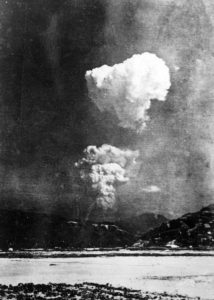 A black and white photograph of an atomic bomb mushroom cloud over Hiroshima