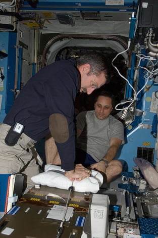 A medical professional administering treatment to an astronaut 