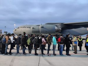 People lined up in front of an Indian Air Force plane