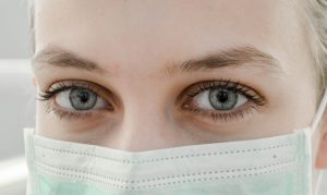 A med student wearing a mask and looking into the camera