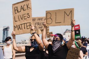 A group of protestors holding signs that read, "Black Lives Matter," and "BLM"