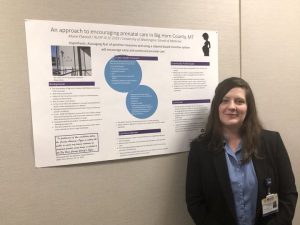 Marie Elwood standing in front of an informational poster about prenatal care