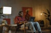 Student sitting in chair with laptop listening to music with headphones on